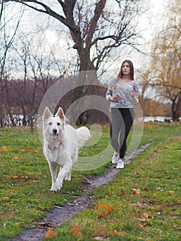 Young girl with dog running at the forest