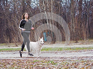 Young girl with dog running at the forest