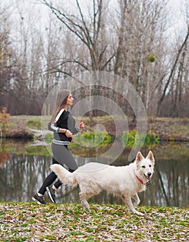 Young girl with dog running at the forest