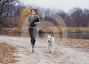 Young girl with dog running at the forest