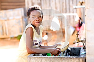 Young girl doing dishes photo