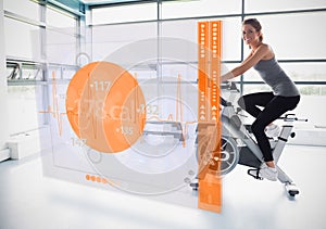 Young girl doing exercise bike with futuristic interface showing calories