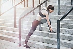 Young girl doing exercises on stadium stairs.