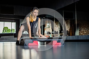 Young girl is doing fitness and different exercises in the gym. Sport is health. Many sports equipment on  e background. Themes of