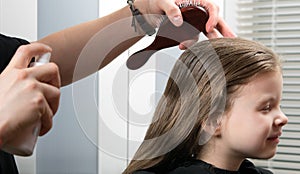 Young girl doing a hairdress, wetting her hair, she smiles photo