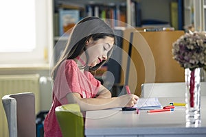 A young girl doing her homework at home during quarantine