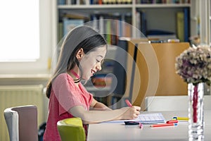 A young girl doing her homework at home during quarantine