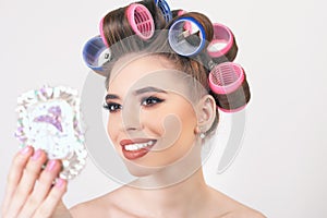 Young girl doing makeup and hairstyle using curlers