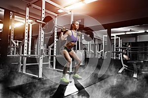 Young girl doing squat exercises with barbell