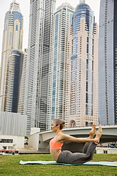 Young girl doing stretching against skyscrapers