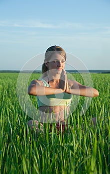 Young girl doing yoga against nature