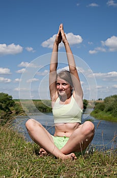 Young girl doing yoga against nature
