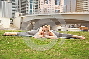 Young girl doing yoga against skyscrapers