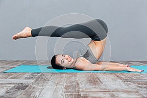 Young girl doing yoga exercise Halasana (Plow Pose)