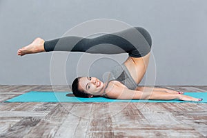 Young girl doing yoga exercise Halasana (Plow Pose) photo