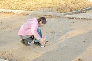 Young girl drawing on sidewalk