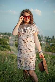 Young girl in dress is having great time during vacation in the summer on sky background in nature, travelling concept