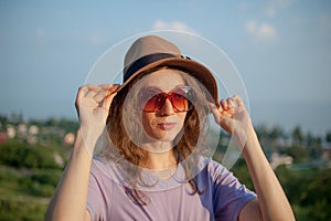 Young girl in dress is having great time during vacation in the summer on sky background in nature, travelling concept