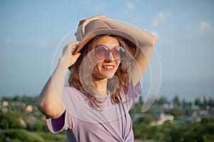 Young girl in dress is having great time during vacation in the summer on sky background in nature, travelling concept