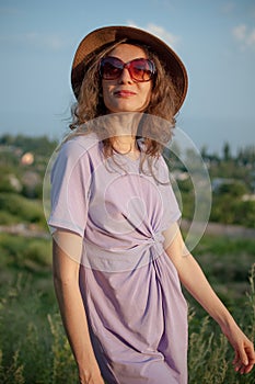 Young girl in dress is having great time during vacation in the summer on sky background in nature, travelling concept