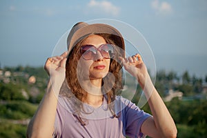 Young girl in dress is having great time during vacation in the summer on sky background in nature, travelling concept