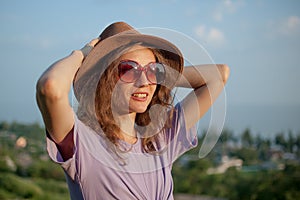 Young girl in dress is having great time during vacation in the summer on sky background in nature, travelling concept