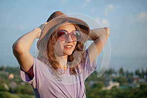 Young girl in dress is having great time during vacation in the summer on sky background in nature, travelling concept