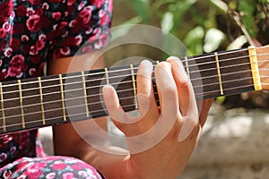 Young girl with a dress playing guitar