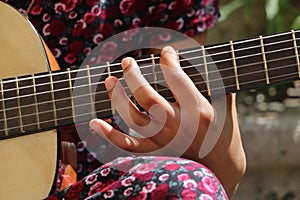 Young girl with a dress playing guitar