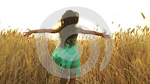 Young girl in the dress is running across the field.