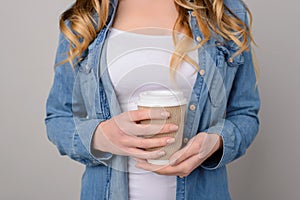Young girl dressed in white t-shirt and jeans shirt isolated on grey background holding cup of takeaway coffee takeaway take away