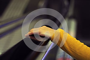 Young girl dressed in yellow going up the mechanical stairs