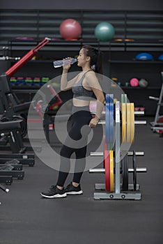 Young girl drink water in gym