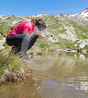 Young girl drinking clean lake water