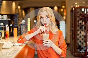 Young girl drinking coffee from tube sitting bar