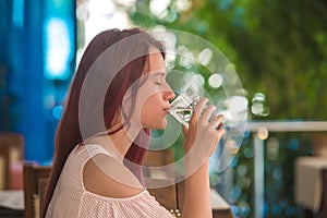 Young girl drinking water from a glass