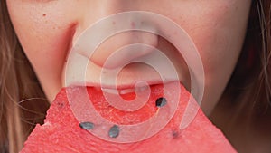 Young girl eat a delicious watermelon slice - close up.