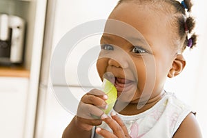 Young girl eating apple indoors photo