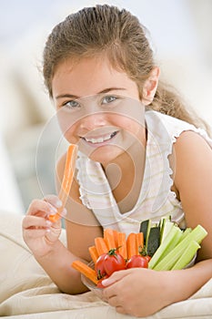 Young girl eating bowl of vegetables