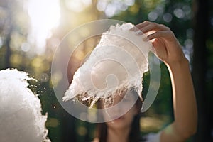 Young girl eating cotton candy at park