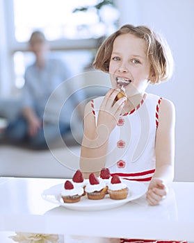Young girl eating cup cake