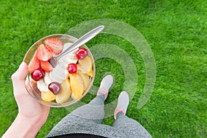 Young girl eating a fruit salad after a workout .