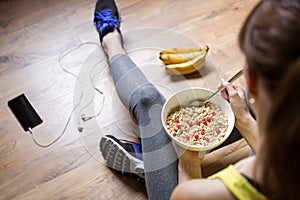 Young girl eating a oatmeal with berries after a workout . Fitness and healthy lifestyle concept.