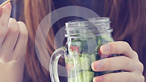 Young girl eating salade.