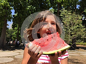 Young girl eating watermelon outdoors