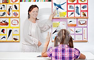 Young girl in elementary science class raising hand