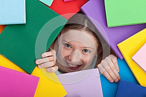 Young girl emerging from beneath books photo