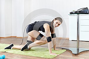 A young girl is engaged in fitness with blue dumbbells