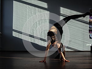 A young girl is engaged in jazz modern dance in the hall.