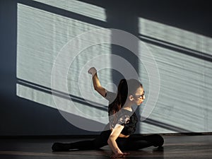 A young girl is engaged in jazz modern dance in the hall.
